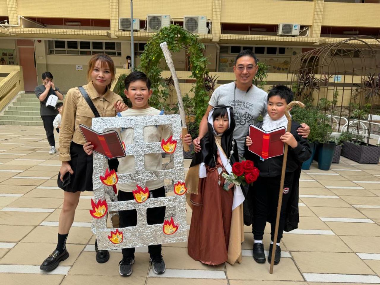 三位負責扮演聖人的同學與家長合照